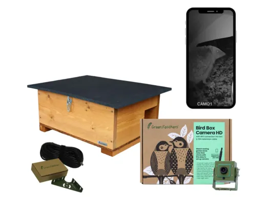 A bird box camera kit featuring a wooden birdhouse, a camera, an instruction box, a cable, and a smartphone displaying a black-and-white image.